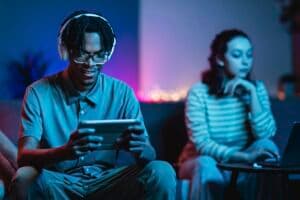casal-em-casa-com-tablet-e-fones-de-ouvido_1-537638