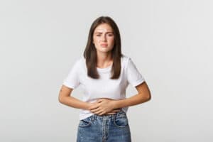 mulher-com-dor-de-estomago-com-as-maos-na-barriga-desconforto-de-colicas-menstruais-menina-com-nauseas-064111