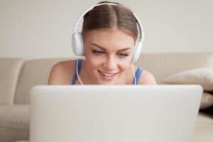 sorrindo-mulher-jovem-desgastar-fones-usando-computador-portatil-headshot_1163-3826-455647