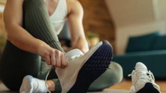 mulher amarrando o tênis